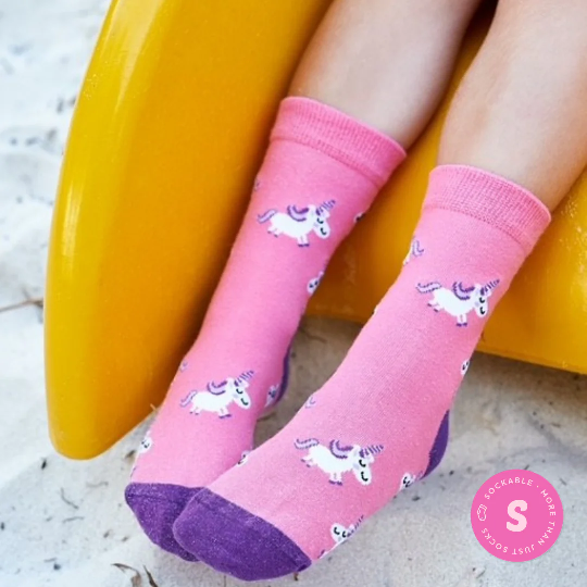 Whimsical crew socks with unicorn print for children on sock model in playground