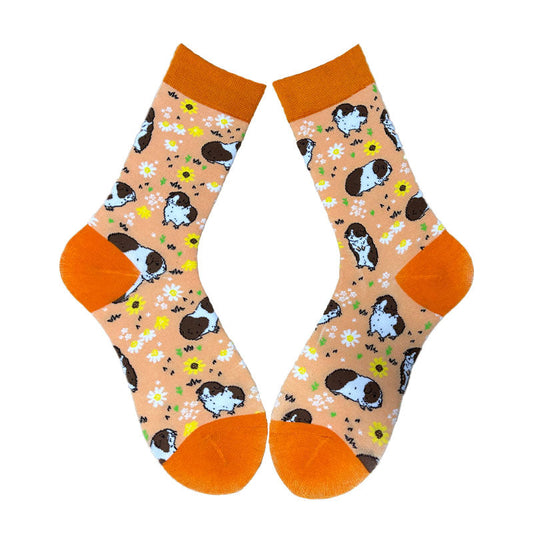 A pair of socks with a floral and animal pattern, featuring guinea pigs in various poses and colors.