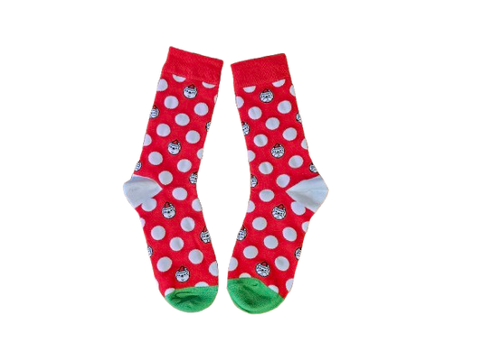 Red socks with white polka dots and green toes on a white background