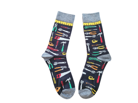 A pair of black tool-themed socks with various tools and a measuring tape printed on the side, designed for adults.